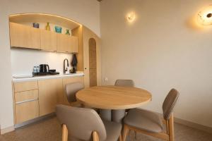a kitchen and dining room with a table and chairs at Inanna Resort in Kifrayyā