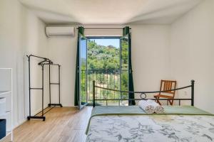 a bedroom with a bed and a large window at Calm apartment in Lepetane in Tivat
