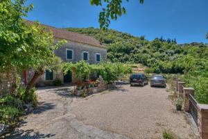 two cars parked in front of a house at Calm apartment in Lepetane in Tivat