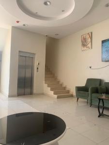 a living room with a couch and a table and stairs at شقق واحة اجا in Hail