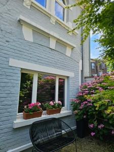 a bench in front of a window with flowers at B&B The Street Lodge in Liège