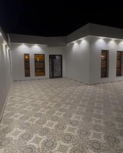 an empty room with a tile floor and windows at شاليه in Al Baha