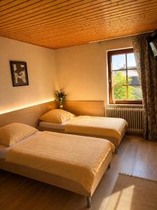 three beds in a room with a window at Manna Haus in Gelnhausen