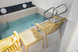 a balcony with two chairs and a swimming pool at 애월현스테이 in Kumori-dong