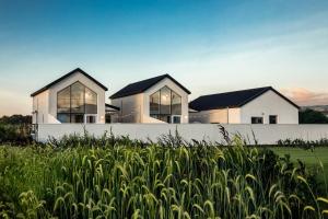 two white houses with windows in a field of grass at 애월현스테이 in Kumori-dong +6 photos