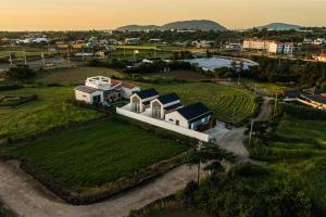 an aerial view of a house on a green field at 애월현스테이 in Kumori-dong