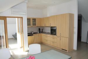 a kitchen with wooden cabinets and white chairs at Allegra am Niederrhein in Neukirchen-Vluyn +11 photos