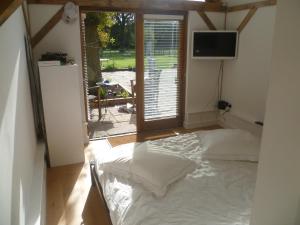 a bedroom with a bed in a room with a window at Little Oak - Small Rural Self Contained Oak Barn Unit - Sleeps 2 in Haslemere