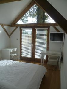 a bedroom with a bed and a desk and a window at Little Oak - Small Rural Self Contained Oak Barn Unit - Sleeps 2 in Haslemere