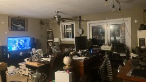 a cluttered living room with a computer and a tv at Philomath place in Philomath