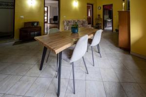 a wooden table with white chairs in a room at Casa Ferrero - appartamenti in Paesana +6 photos