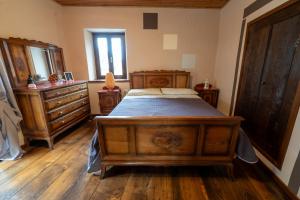 a bedroom with a wooden bed and a dresser at Casa Ferrero - appartamenti in Paesana