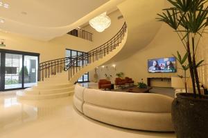 a living room with a spiral staircase and a couch at Grand Maison Hotel in Porto Velho