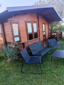 a cabin with chairs and a table in front of it at Domek letniskowy u Bodzia in Kruklanki