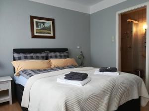 a bedroom with a bed with two towels on it at Baltic Cafe & Concept Store in Maasholm