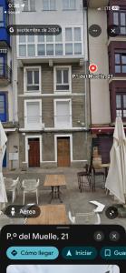 a picture of a building with a table and chairs at La Casina del Puerto in Luarca