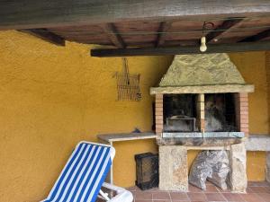 a patio with a stone oven and a blue and white chair at BLEU MAISON-PAZO 1 CL in Campo Lameiro