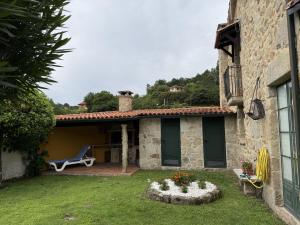 a house with a patio and a chair on a yard at BLEU MAISON-PAZO 1 CL in Campo Lameiro