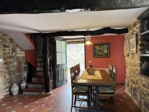 a dining room with a table and a stone wall at BLEU MAISON-PAZO 1 CL in Campo Lameiro