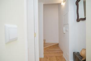 een hal met een witte deur en houten vloeren bij Little River View Triplex in Alfama in Lissabon