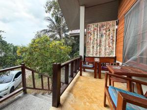 a balcony with a table and chairs on a house at Neziha's Homes in Thong Sala