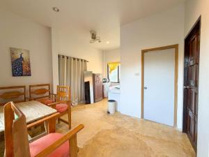 a living room with a table and chairs and a kitchen at Neziha's Homes in Thong Sala +17 photos