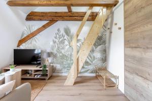 a living room with a staircase with a mural of plants at Le Green Escape in Sélestat