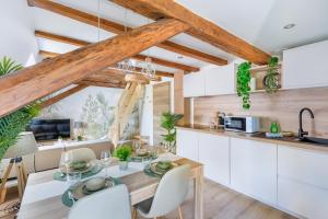 a kitchen with white cabinets and a table and chairs at Le Green Escape in Sélestat