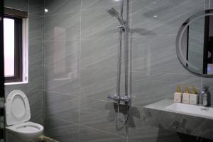 a bathroom with a shower and a toilet and a sink at Chải Eco House in Mù Cang Chải