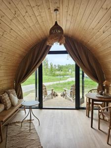 a room with a large window and a couch at Tiny House De Bosksjonger in Westergeest