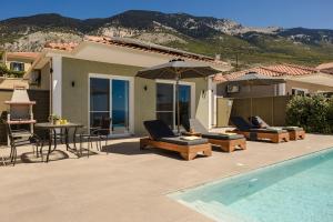a patio with chairs and a table and a pool at Ionian Dreaming in Lourdata