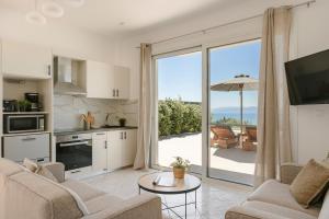 a kitchen and living room with a view of a patio at Ionian Dreaming in Lourdata