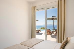 a bedroom with a bed and a view of the ocean at Ionian Dreaming in Lourdata +15 photos