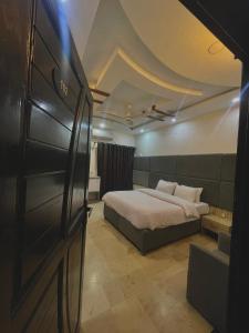 a bedroom with a bed in a room with a door at Aban Guest House in Peshawar