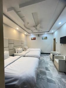 a room with a row of beds in it at Aban Guest House in Peshawar