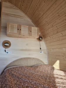 a bed in a room with a wooden ceiling at Tiny House De Bosksjonger in Westergeest