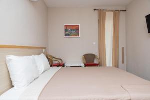 a bedroom with a bed and a chair at Apartments Ribarica in Karlobag