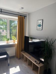 a living room with a flat screen tv and a window at Ziemeļblāzma in Riga