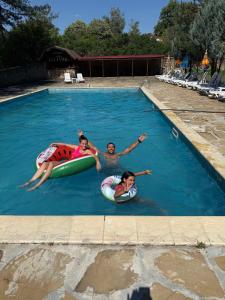 three people floating in a swimming pool at Хотел Галина Палас in Srem