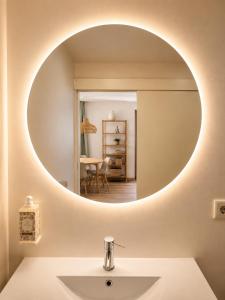 a bathroom with a round mirror above a sink at Terra Clara Studios & Apartments in Esposende +52 photos