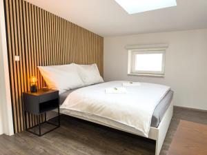 a bedroom with a large white bed and a window at APARTMÁNY za divadlem in Broumov