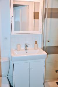 a bathroom with a white sink and a mirror at Dormir à Brioude - appartement 'esprit dune' in Brioude