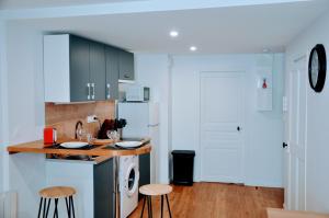 a kitchen with a counter and two stools in it at Dormir à Brioude - appartement 'esprit dune' in Brioude +12 photos