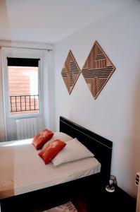 a bedroom with a bed with red pillows and hearts on the wall at Dormir à Brioude - appartement 'esprit dune' in Brioude