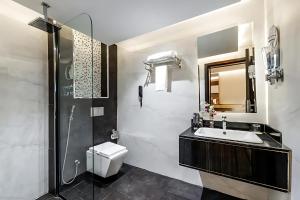 a bathroom with a sink and a toilet and a shower at فندق اورا ميلينيوم in Al Maraghah +20 photos