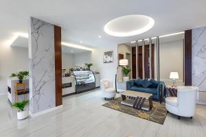 a living room with a blue couch and chairs at فندق اورا ميلينيوم in Al Maraghah