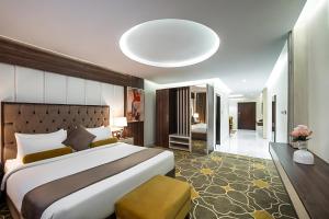 a large bedroom with a large bed and a large mirror at فندق اورا ميلينيوم in Al Maraghah