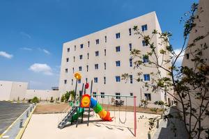 a playground in front of a building at فندق اورا ميلينيوم in Al Maraghah