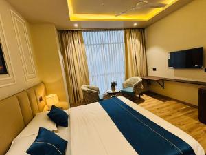 a hotel room with a bed and a flat screen tv at The Grand Dularia in Nagpur