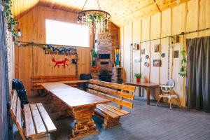 a dining room with wooden benches and a table at Lisie Bagno - Domki w Lesie Mazury in Miłomłyn